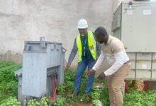 Mr Otoo with a colleague inspecting one of the vandalized switchgears at the Airport residential area