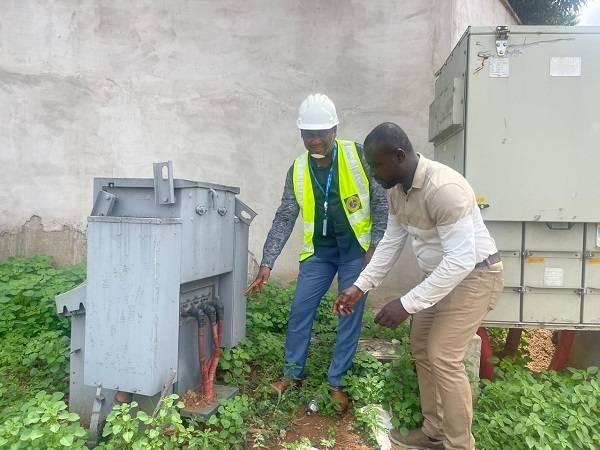 Mr Otoo with a colleague inspecting one of the vandalized switchgears at the Airport residential area