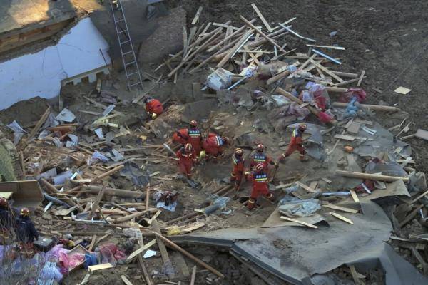 • Rescuers climb through damaged buildings in Kangdiao village in Jishishan county