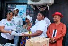 Ms Garglo (left) presenting a start-up kit to a beneficiary for her enrolment