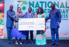Vice President Dr Bawumia(in smock) presenting a dummy cheque to Ms Charity Akortia(second from right) the overall National best Farmer. With them include Dr Bryan Acheampong (right)Agric Minister .