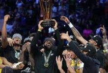 • LeBron James hoists the trophy with his teammates after winning the game