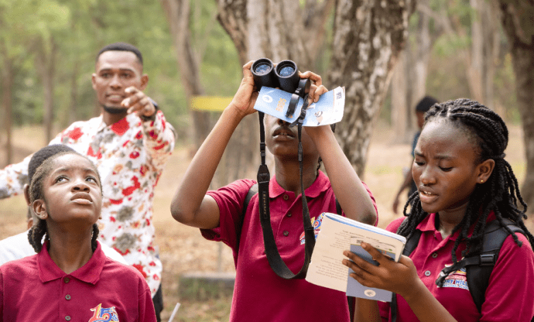 Birdwatching and notes taking by school children at event.