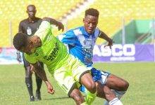 • Bechem United’s Emmanuel Annor (in green) trying to go past Raymond Oko Grippman of Olympics in Wednesday’s game Photo: Raymond Ackumey
