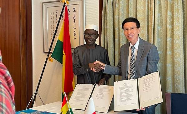 Mr Hisanobu (right) exchanging the MoU with Mr Adams after the signing ceremony