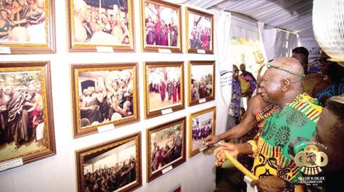 The Asantehene, Otumfuo Osei Tutu ll, admiring some of the museum's framed photographs.