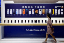 A woman walks past a counter displaying mobile phones at the Qualcomm booth during the 2021 China International Fair for Trade in Services (CIFTIS) in Beijing, China September 4, 2021. REUTERS/Florence Lo/File Photo Purchase Licensing Rights